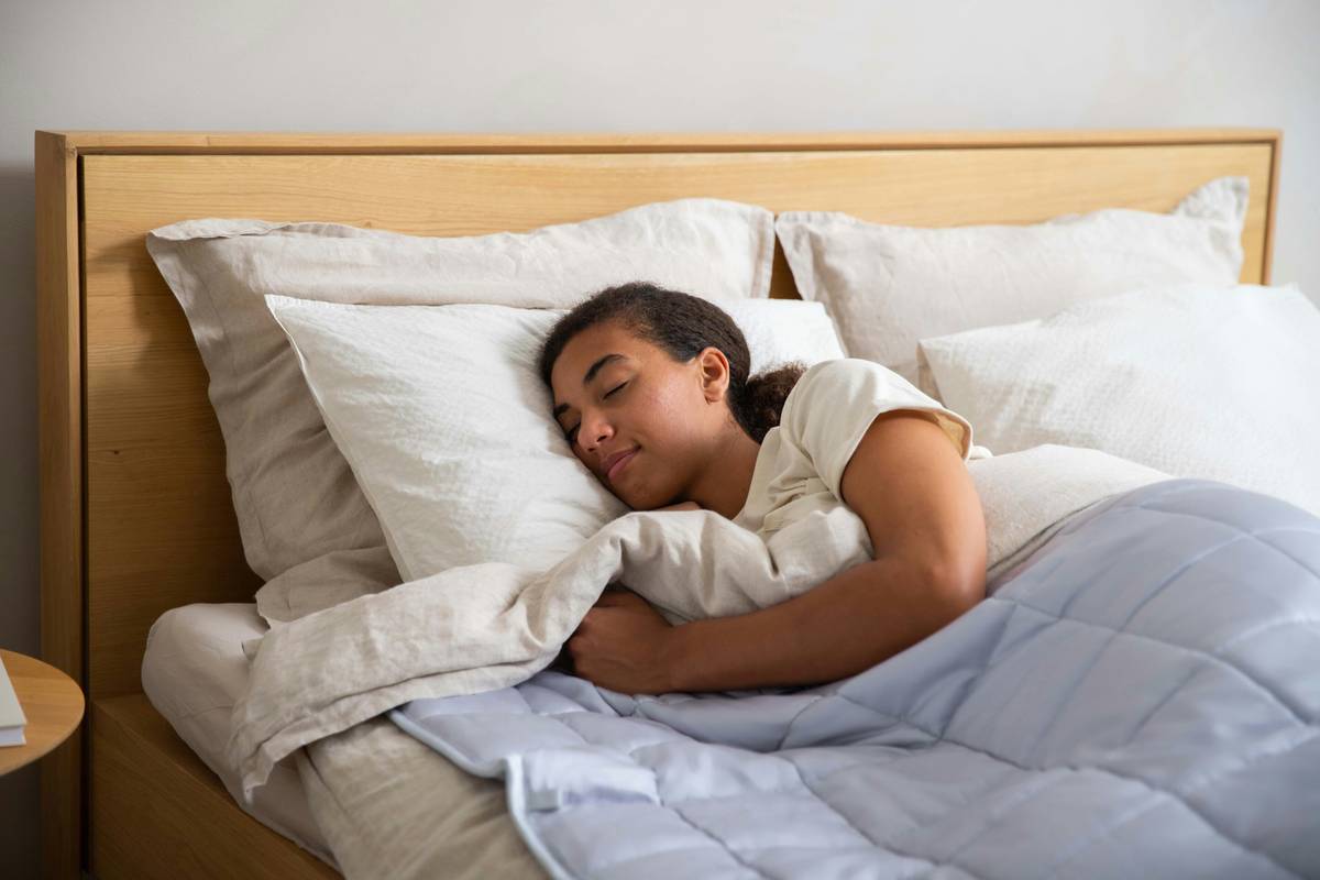 sleep quality improvement tip creating a cozy, dimly lit bedroom with blackout curtains and a warm bedside lamp